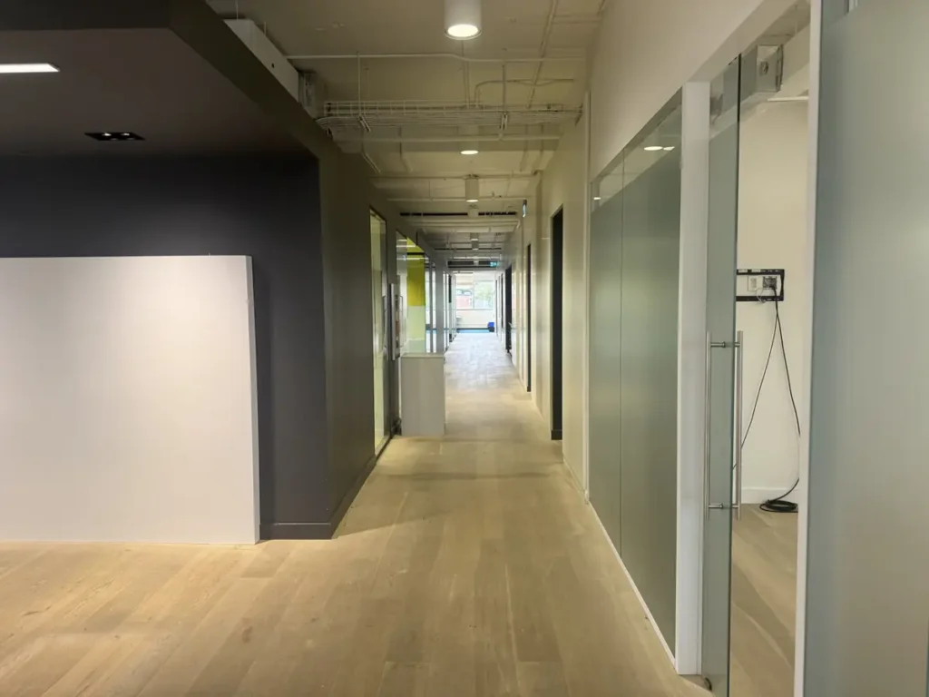 Loft-style office corridor with enclosed glass offices – 4200 Saint-Laurent, Montreal